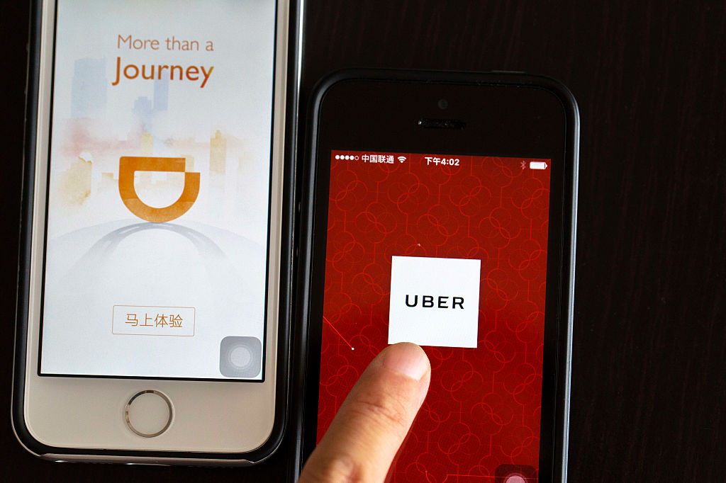 BEIJING, CHINA - 2016/08/02: Apps of Uber and Didi Chuxing on smart phone.  Uber is selling its operation in China to its chief rival, Didi Chuxing, in exchange for a 20 percent stake.  The deal is waiting for the government's approval.  From Nov.1, 2016,  ride-hailing services will be legitimate in China, but those offering rides below cost are prohibited. (Photo by Zhang Peng/LightRocket via Getty Images)