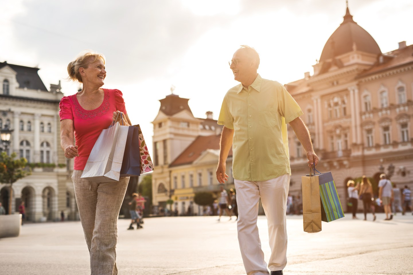 Happy senior couple talking while shopping in the city.