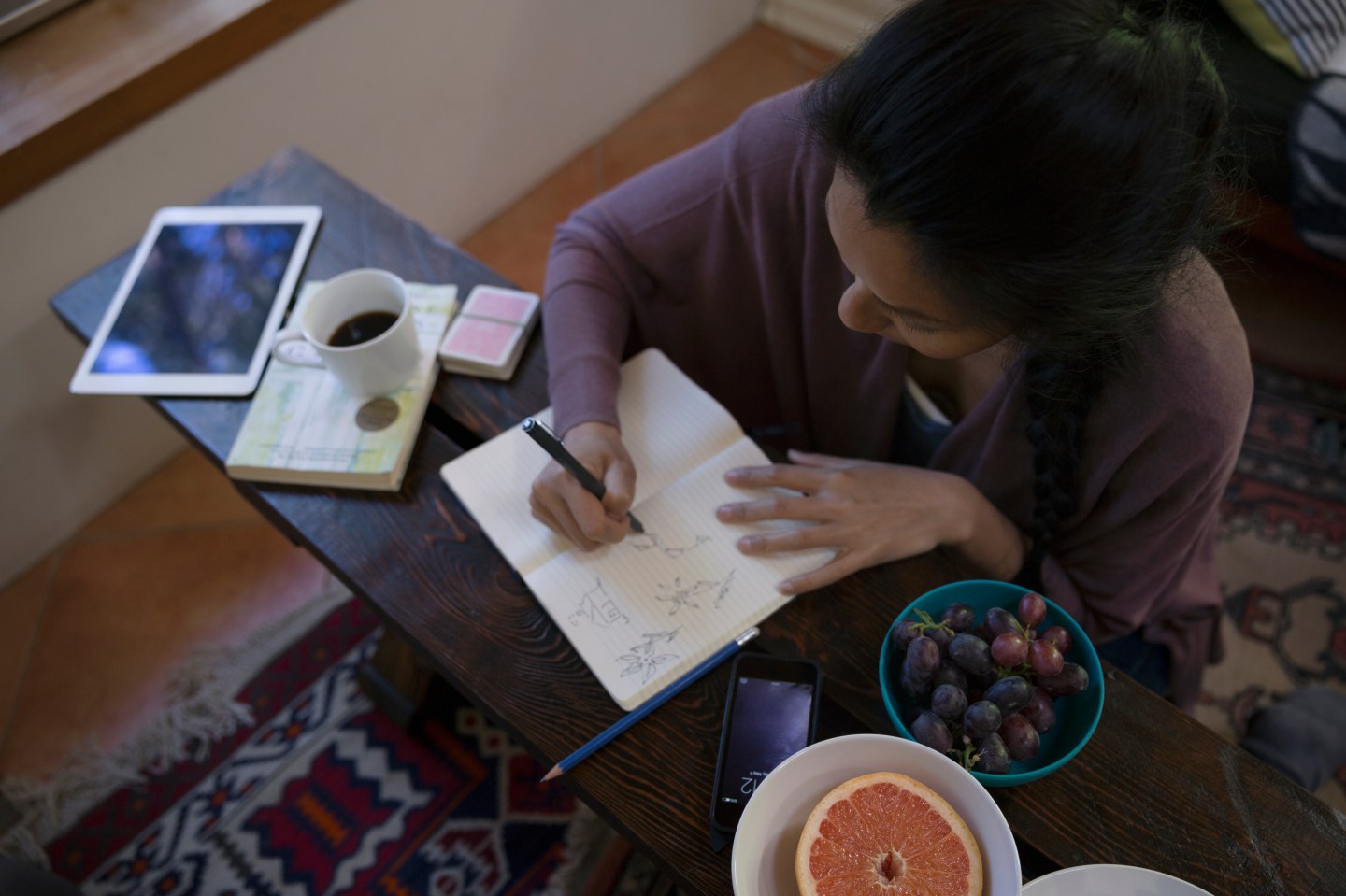 Woman sketching in journal in living room