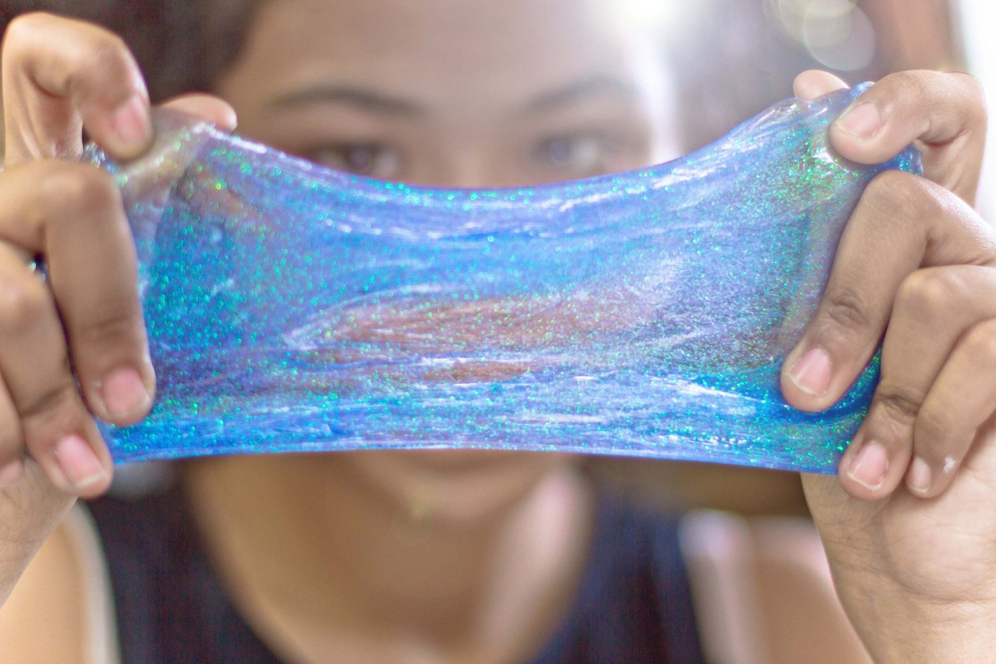 Girl making blue glitter slime