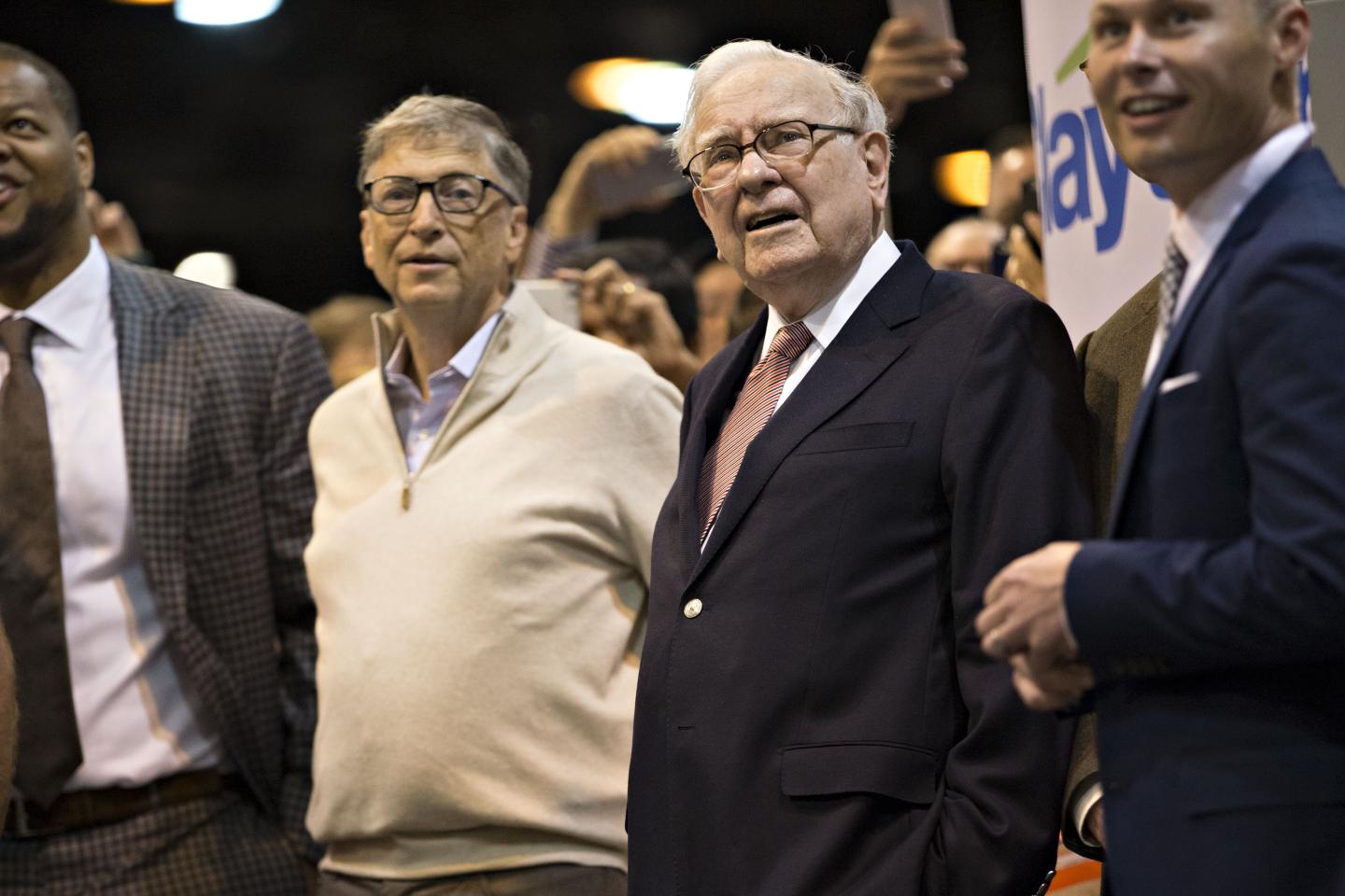 Warren Buffett, chairman and chief executive officer of Berkshire Hathaway Inc., center right, and Bill Gates, billionaire and co-founder of the Bill and Melinda Gates Foundation, watch a newspaper toss at the Berkshire Hathaway annual meeting in Omaha, Nebraska, U.S., on Saturday, May 6, 2017.