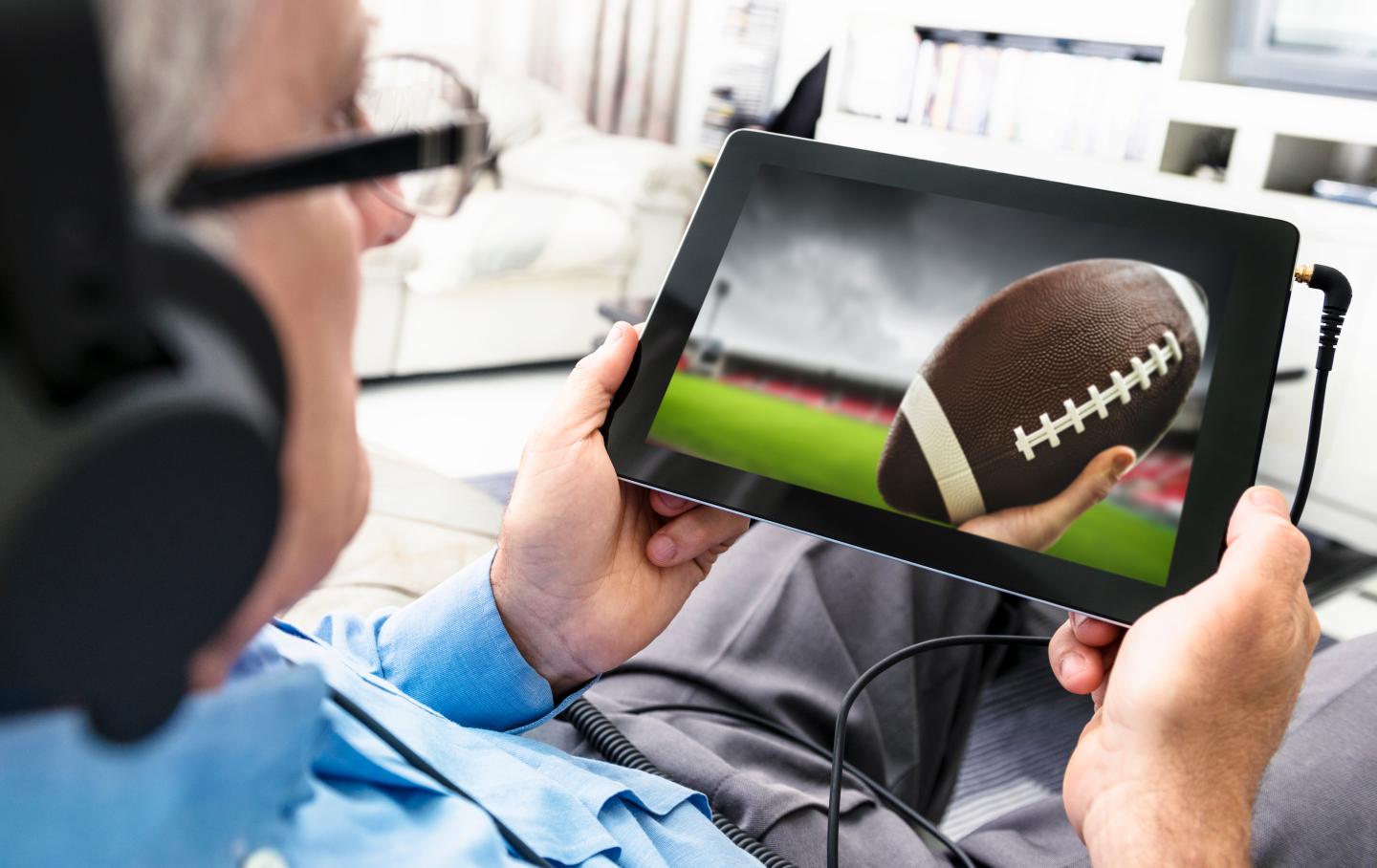 Man watching a football game on the tablet