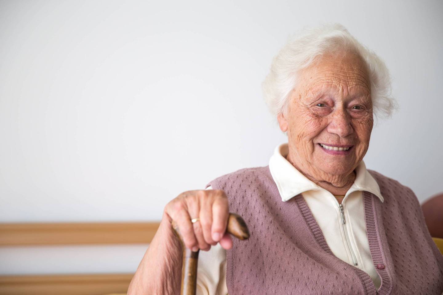 Portrait Of Smiling Senior Woman Relaxing In Her Bedroom At The Retirement Home