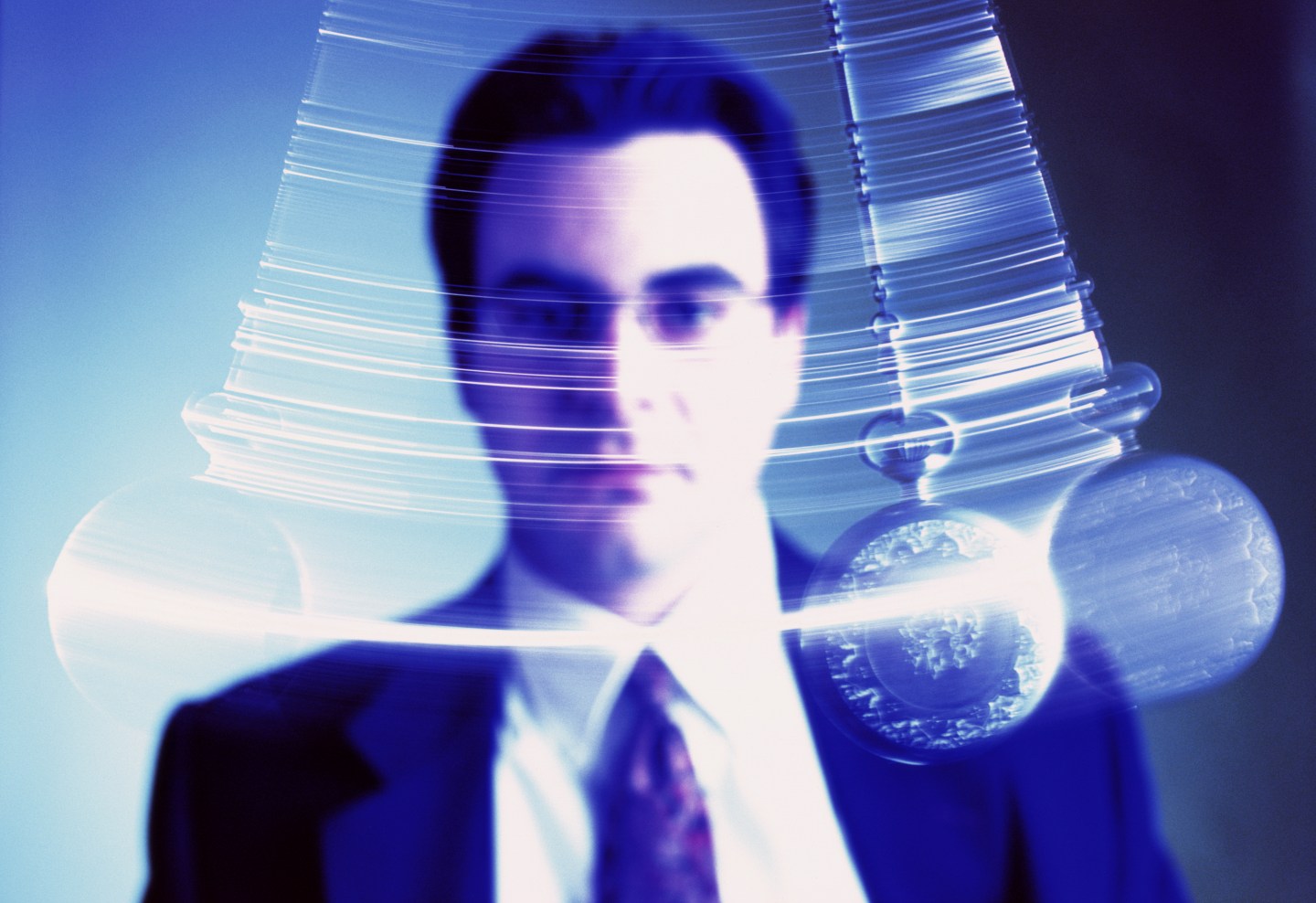 Businessman watching swinging pendulum (Digital Enhancement)