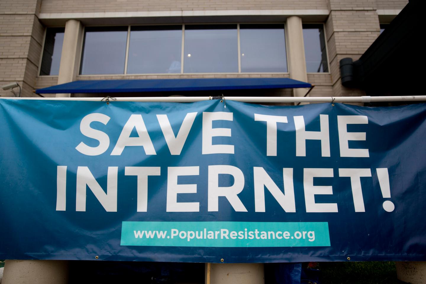 A sign reading "SAVE THE INTERNET!" in support of net neutrality stands outside the Federal Communications Commission (FCC) headquarters in Washington, D.C., U.S., on Wednesday, May 14, 2014.
