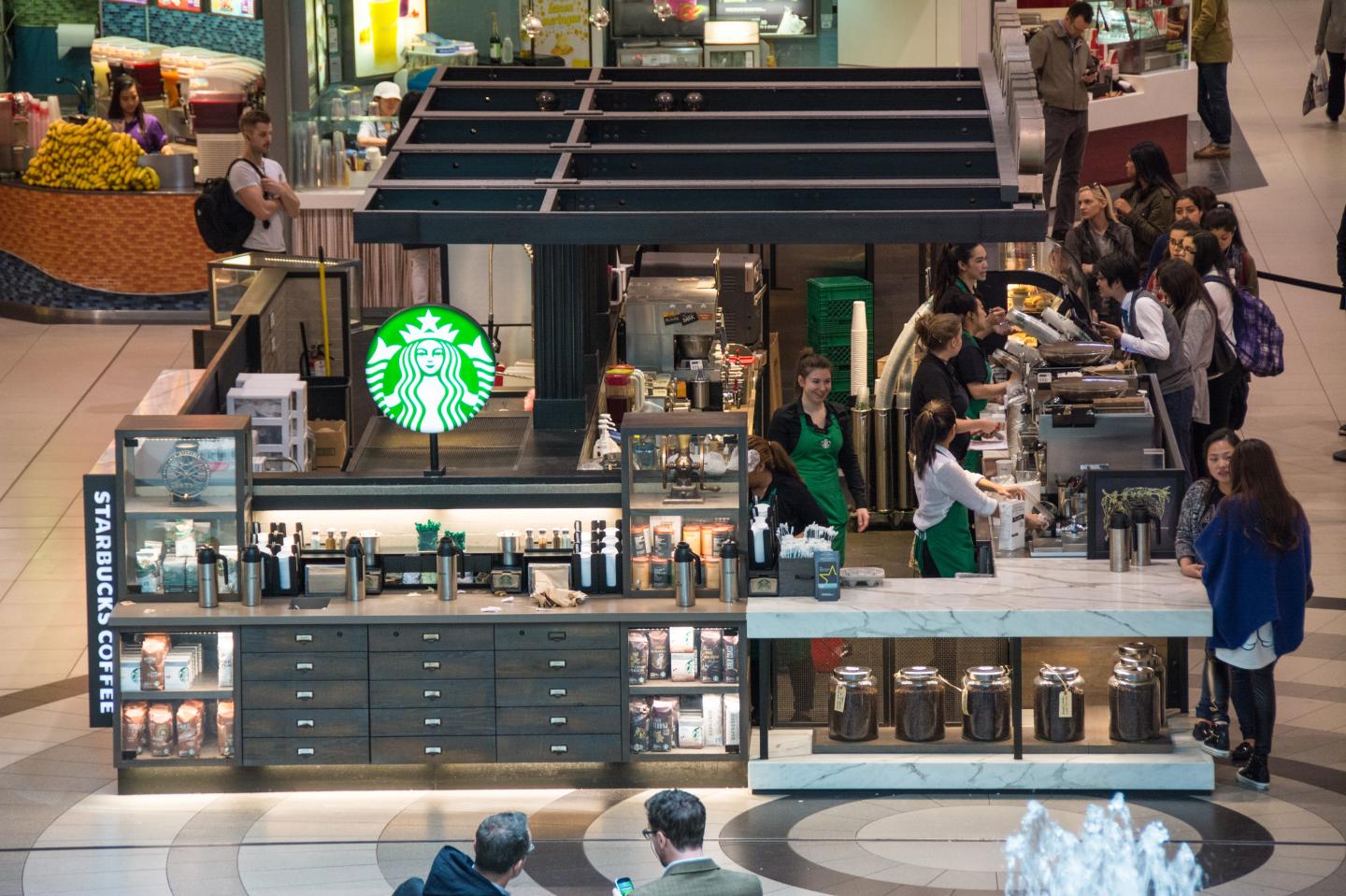 Starbucks in a shopping mall. Four baristas surround a