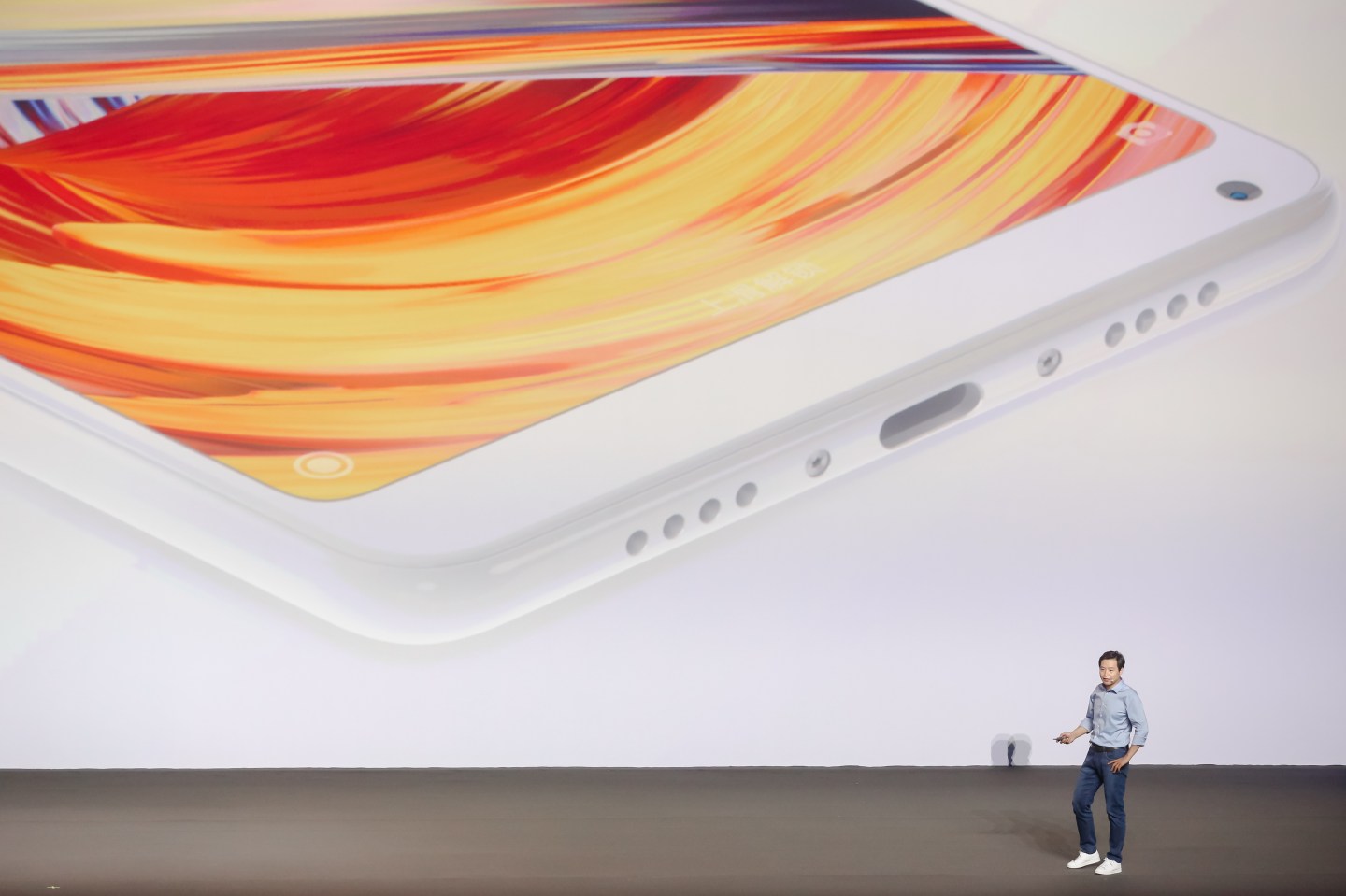 Lei Jun, Chairman and Chief Executive Officer of Xiaomi Inc., delivers a speech with a large smartphone in the background during a launch event at Beijing University of Technology on September 11, 2017 in Beijing, China.