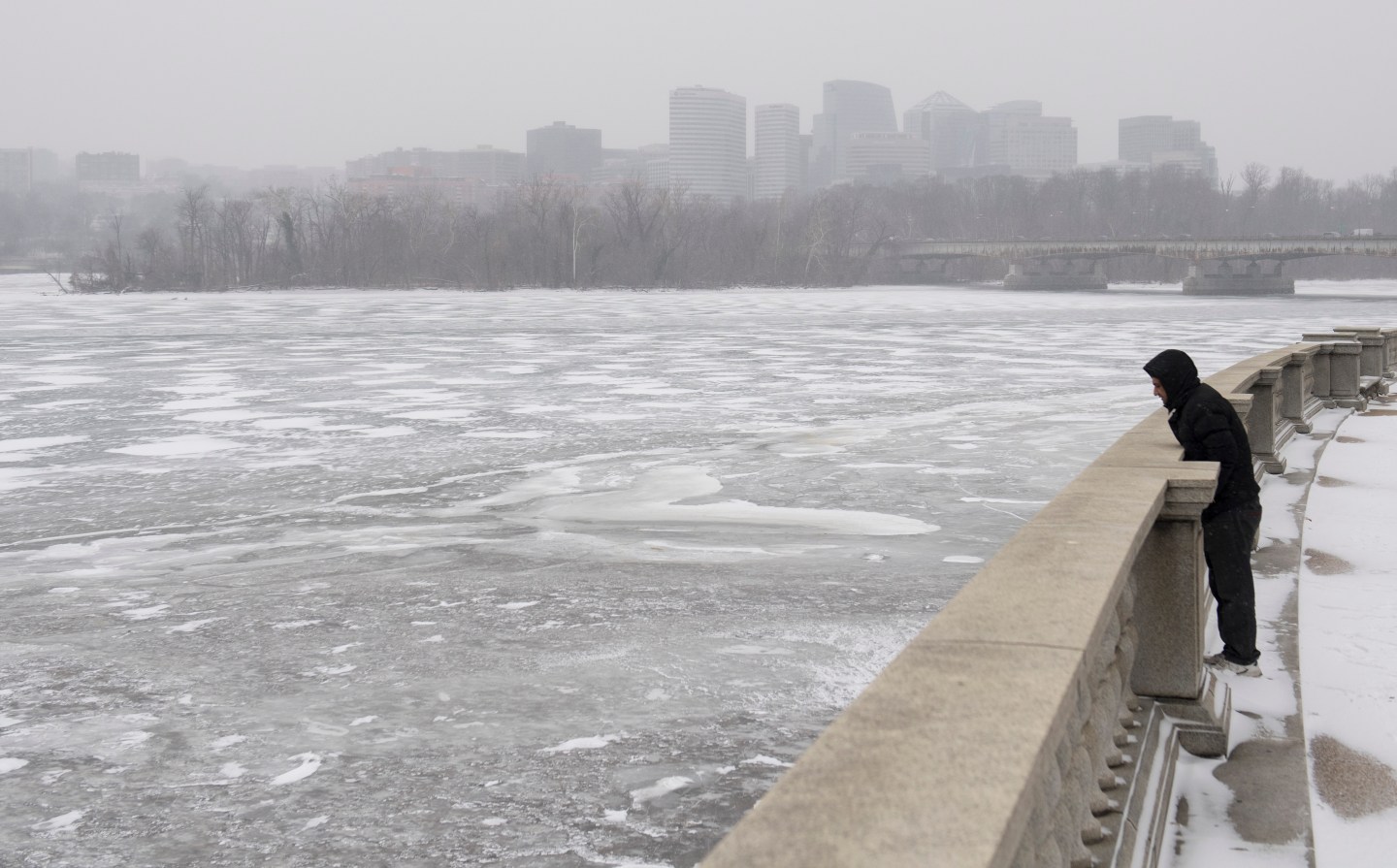 A man looks out over a frozen Potomac River during a snow storm in Washington, DC, January 4, 2018.