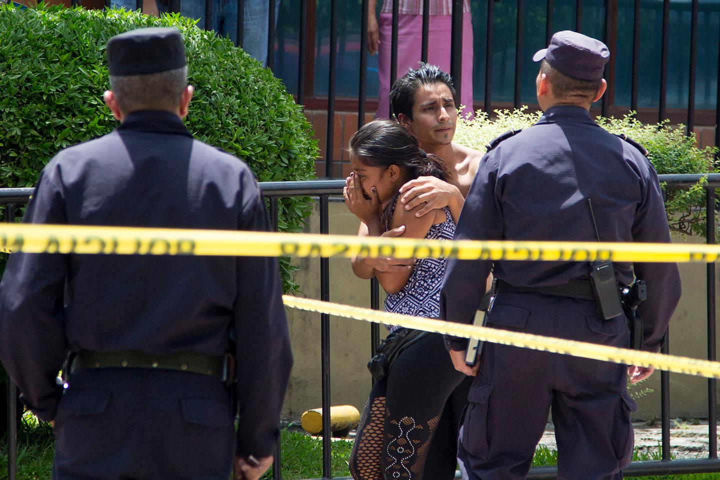 Onlookers are upset at the crime scene of a Salvadoran vendor of candies and soft drinks who was gunned down in downtown San Salvador, El Salvador.