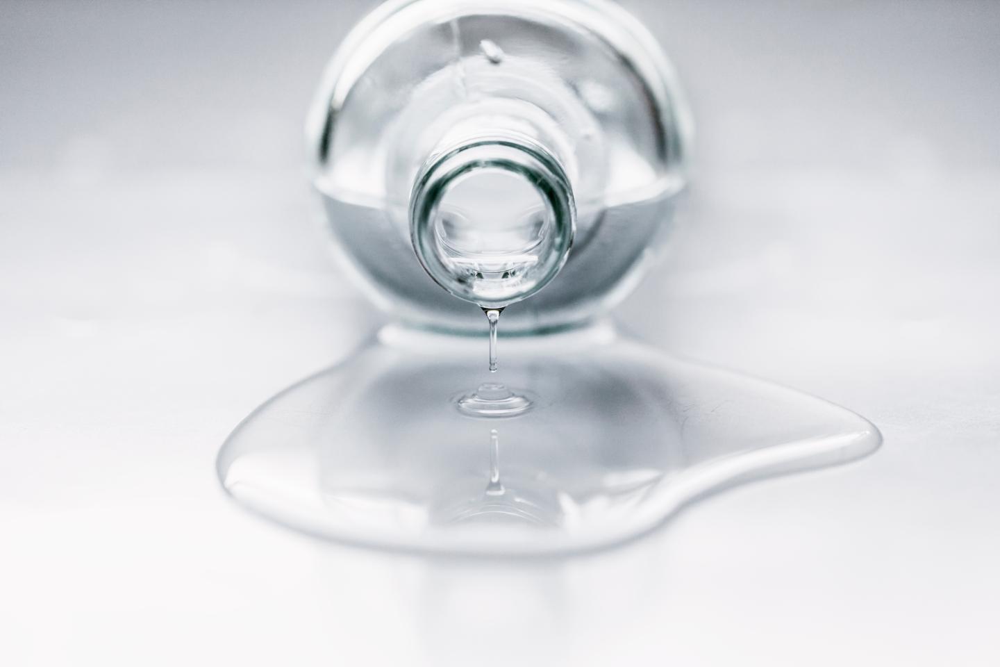 Bottle lying on table with water coming out
