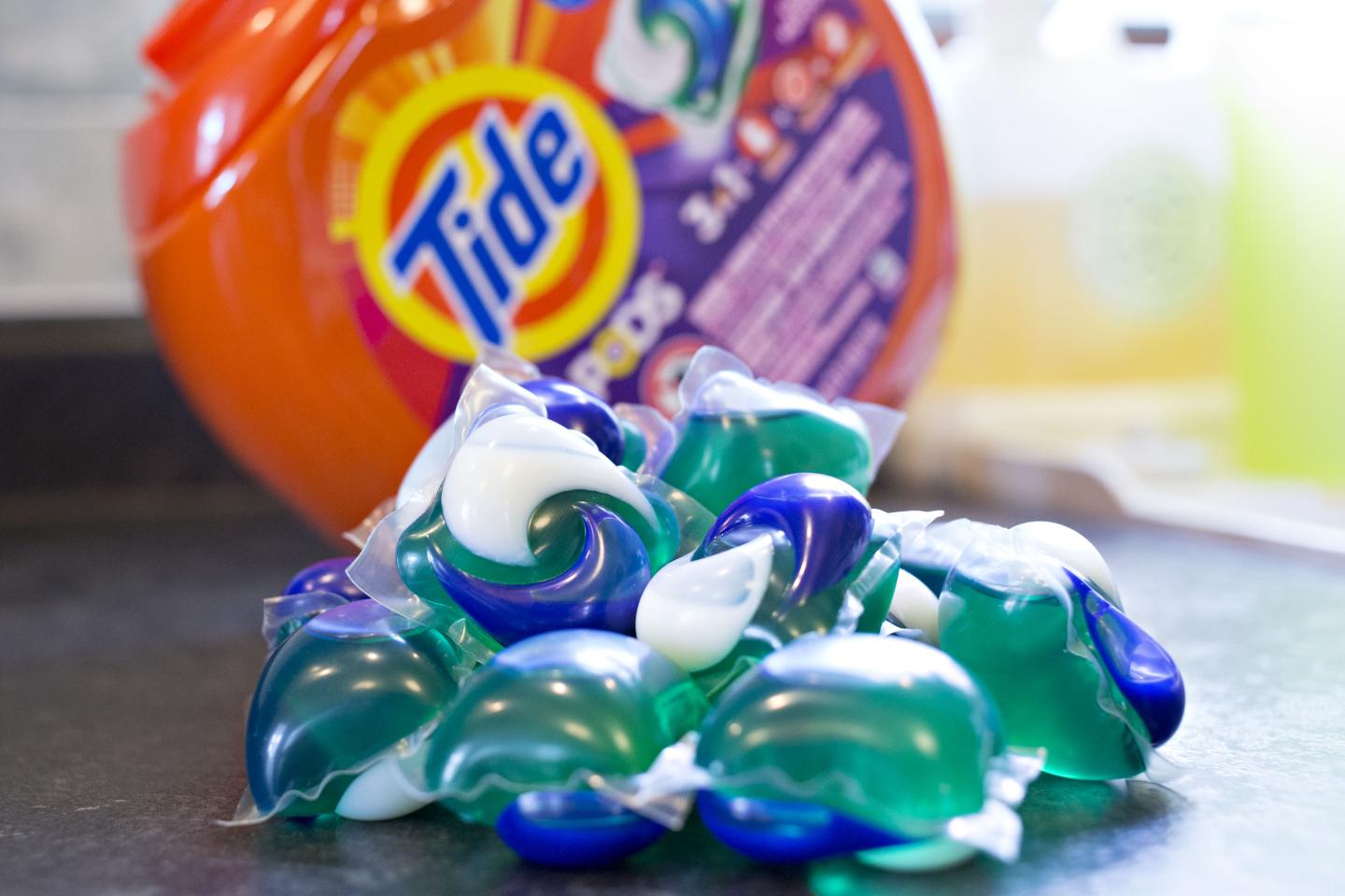 Procter & Gamble Tide Pods laundry detergent packs are piled in front of their container.