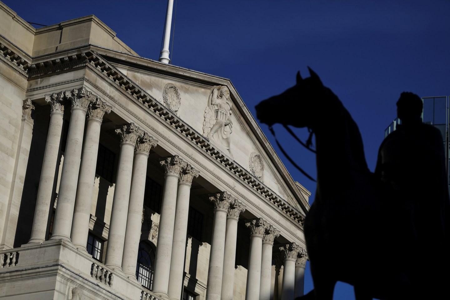 FILE PHOTO: A statue is silhouetted against the Bank of England in the City of London