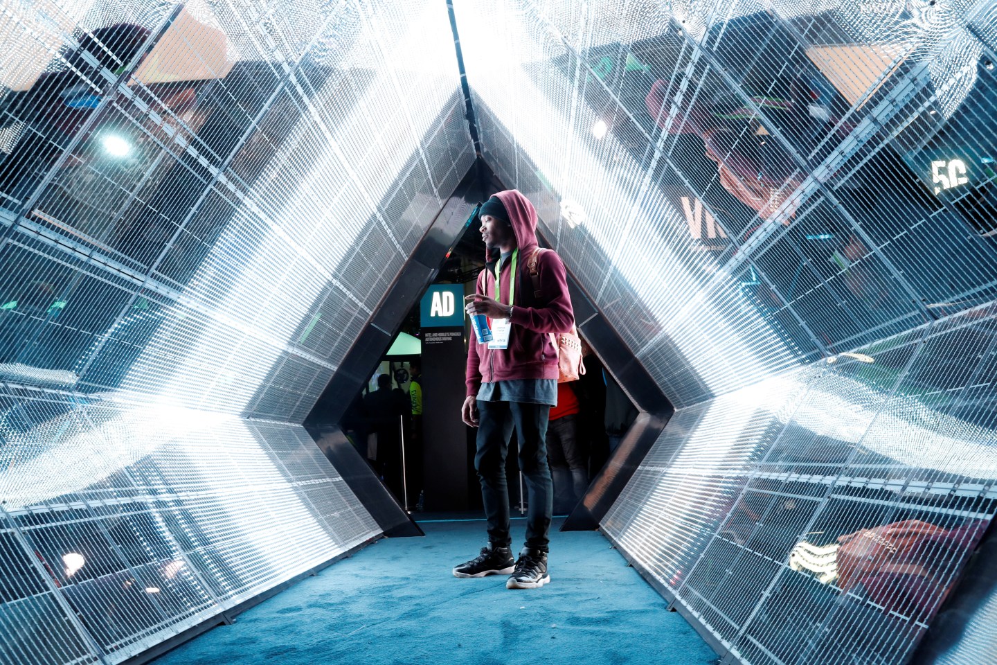 Jordan Jtakin walks though a 5G wireless broadband technology display in the Intel booth during the 2018 CES in Las Vegas