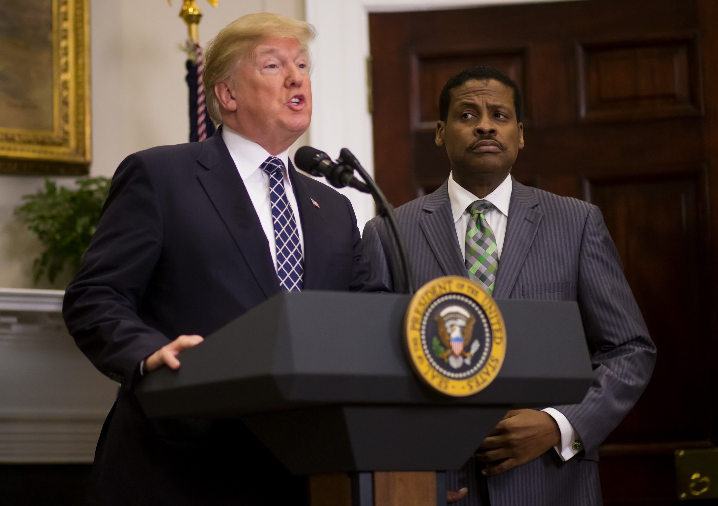 U.S. President Donald Trump, left, speaks while Martin Luther King Jr.'s nephew Isaac Newton Farris Jr. listens before the signing of a proclamation in the Roosevelt Room of the White House in Washington, D.C., U.S., on Friday, Jan. 12, 2018.
