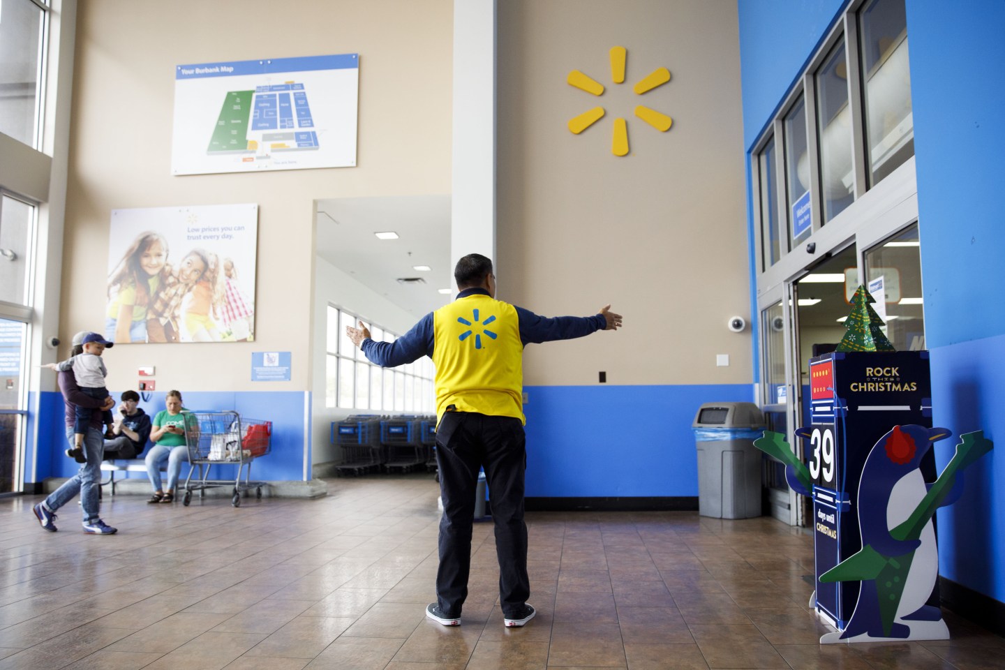 An employee welcomes customers at a Walmart location in Burbank, California, U.S., on Thursday, Nov. 16, 2017.