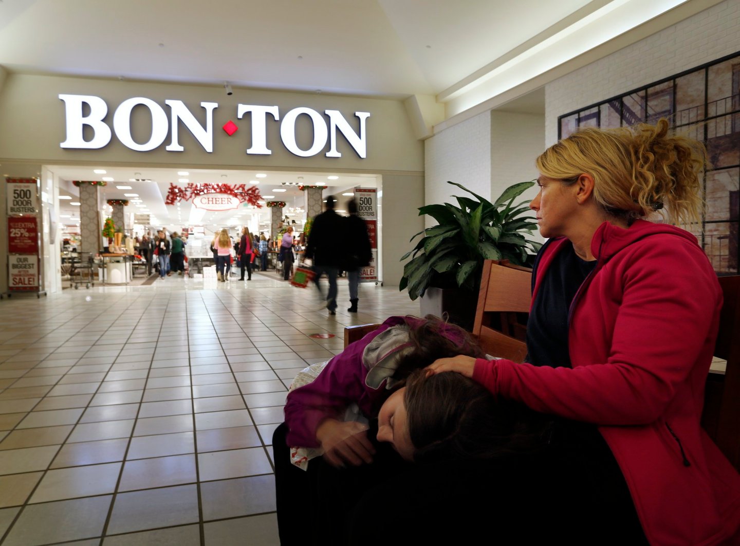 Zoe Sweet of Westbrook rests with her daughter, Lucy, 10, as she waits for another daughter and her