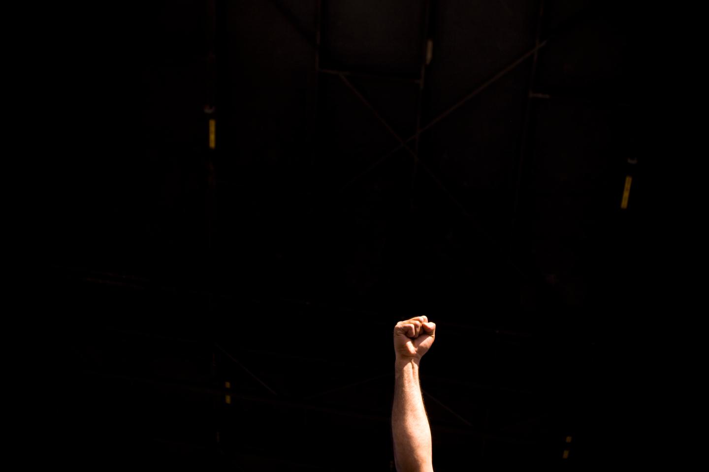 Fist raised in protest against black background