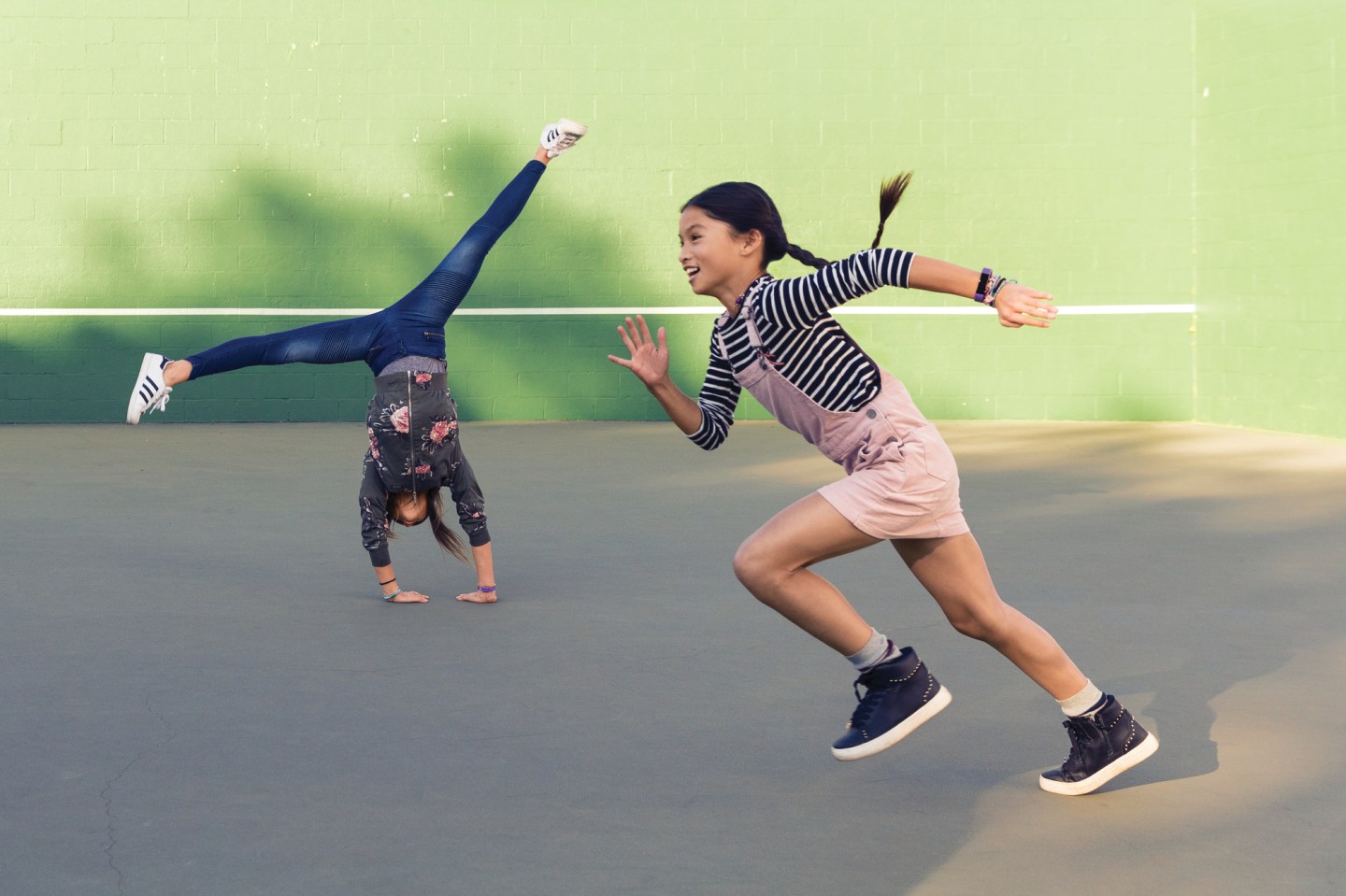 Girls playing while wearing the Fitbit Ace.