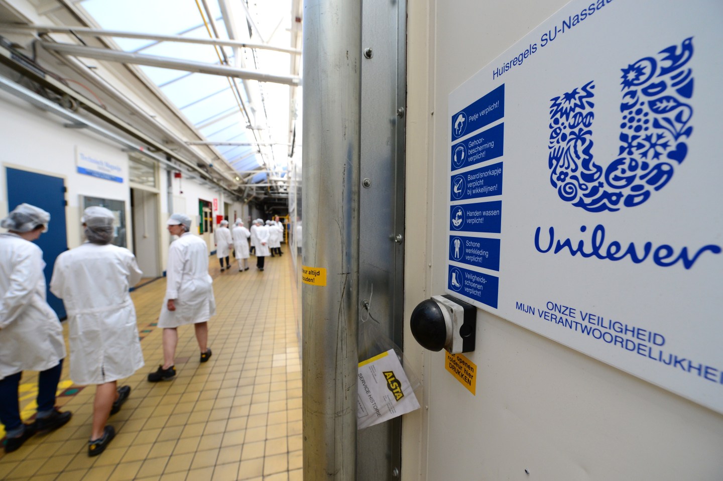 Employees walk past Unilever logo at Netherlands headquarters