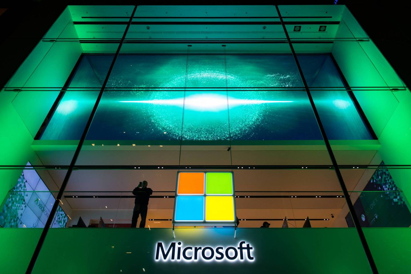 Person's silhouette appears besides Microsoft's logo in office building