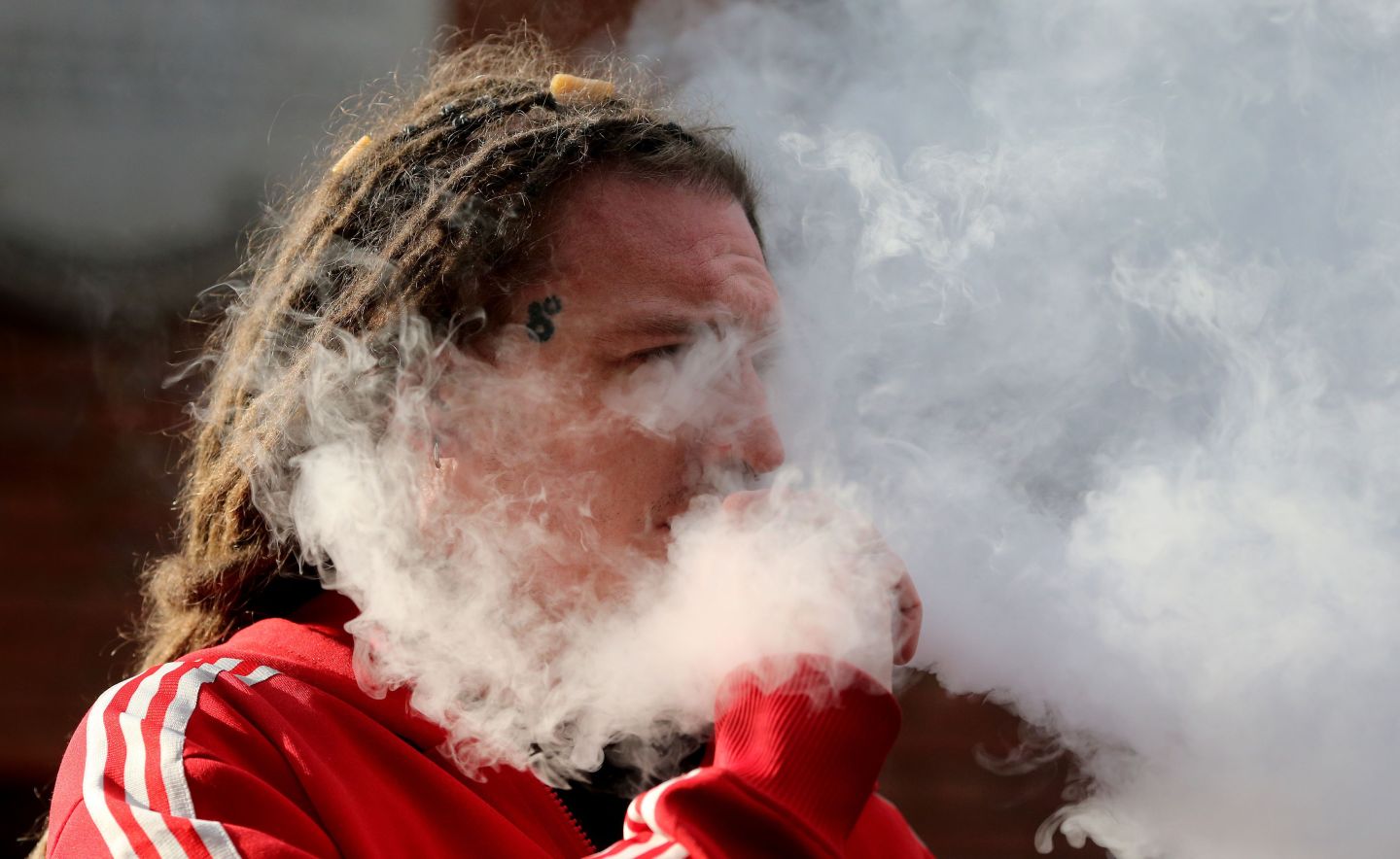 Man is surrounded by vape of e-cigarette