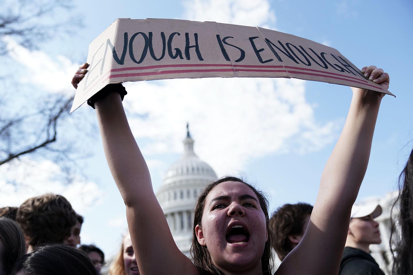 Student holds 'Enough is Enough' banner in front of US Capitol to protest gun violence in schools.