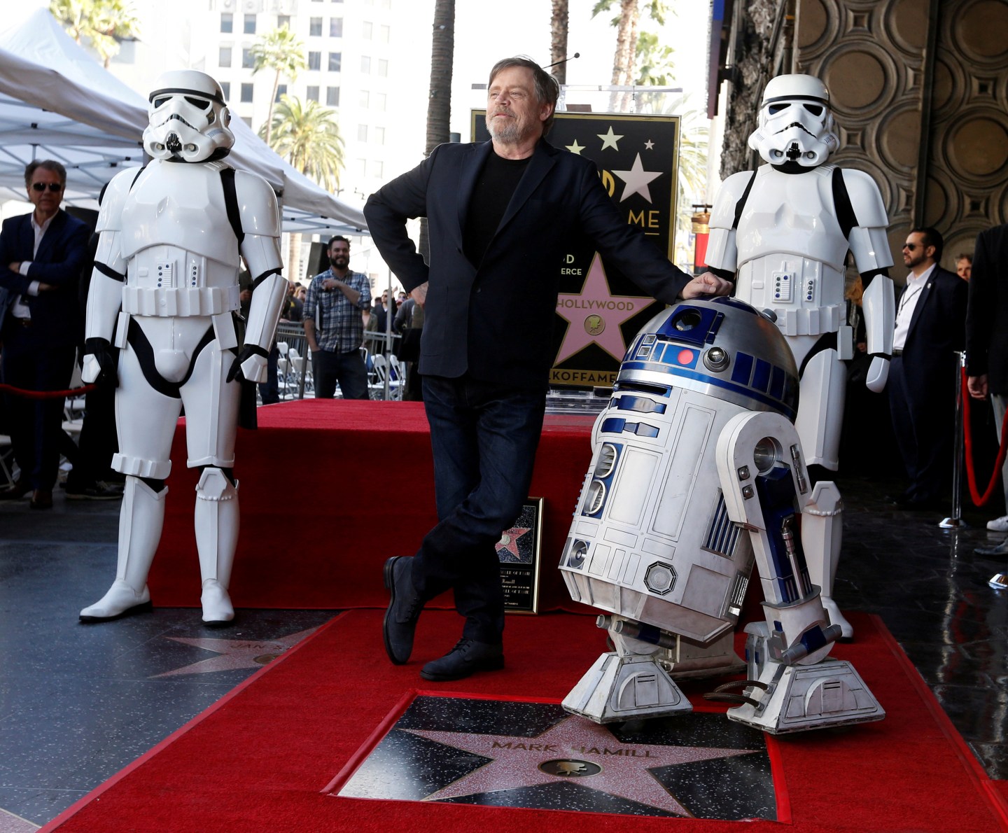 Actor Mark Hamill poses with "Star Wars" characters R2-D2 and Stormtroopers after unveiling his star on the Hollywood Walk of Fame in Los Angeles