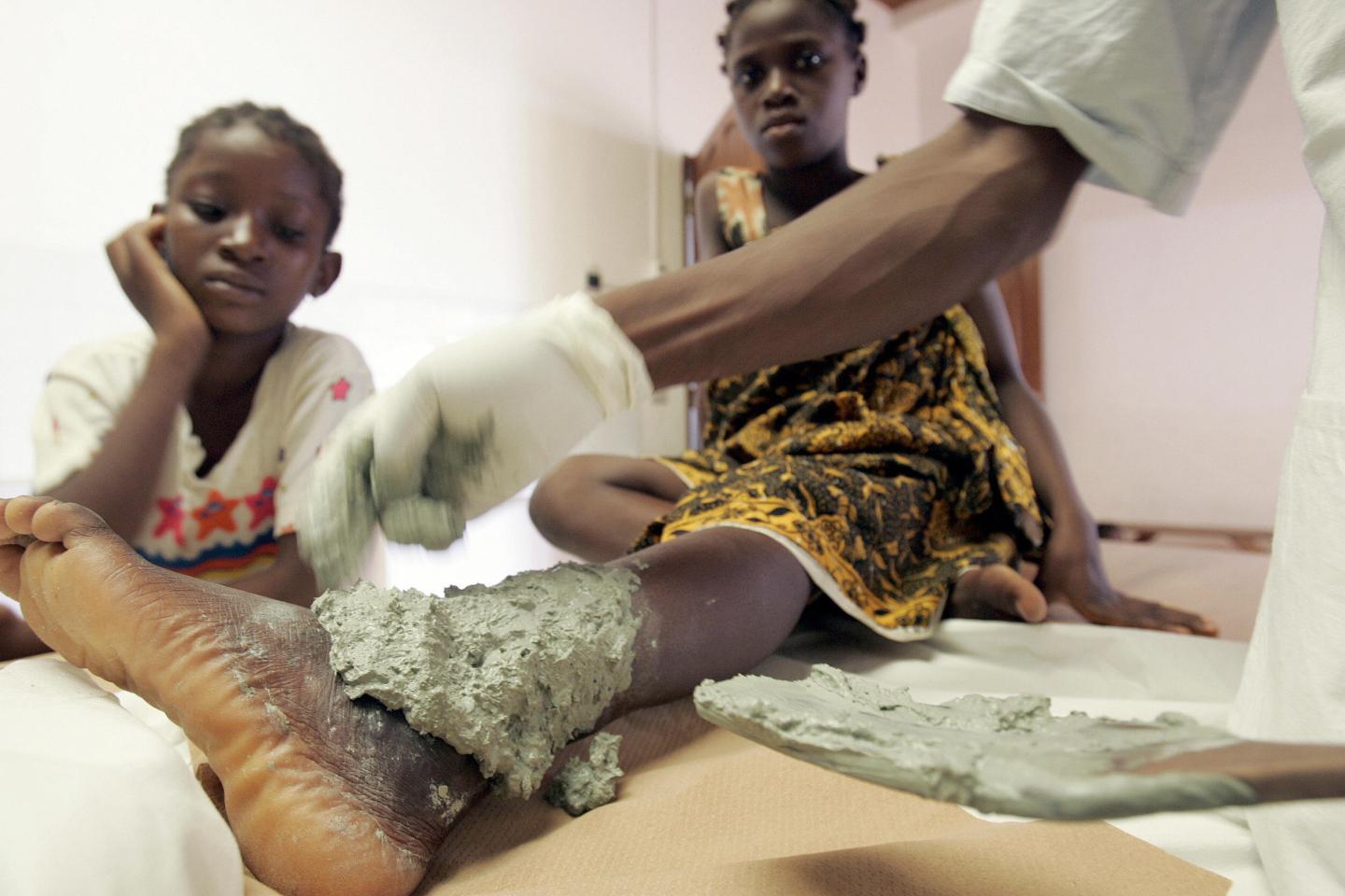 A nurse treats an Ivorian woman sufferin