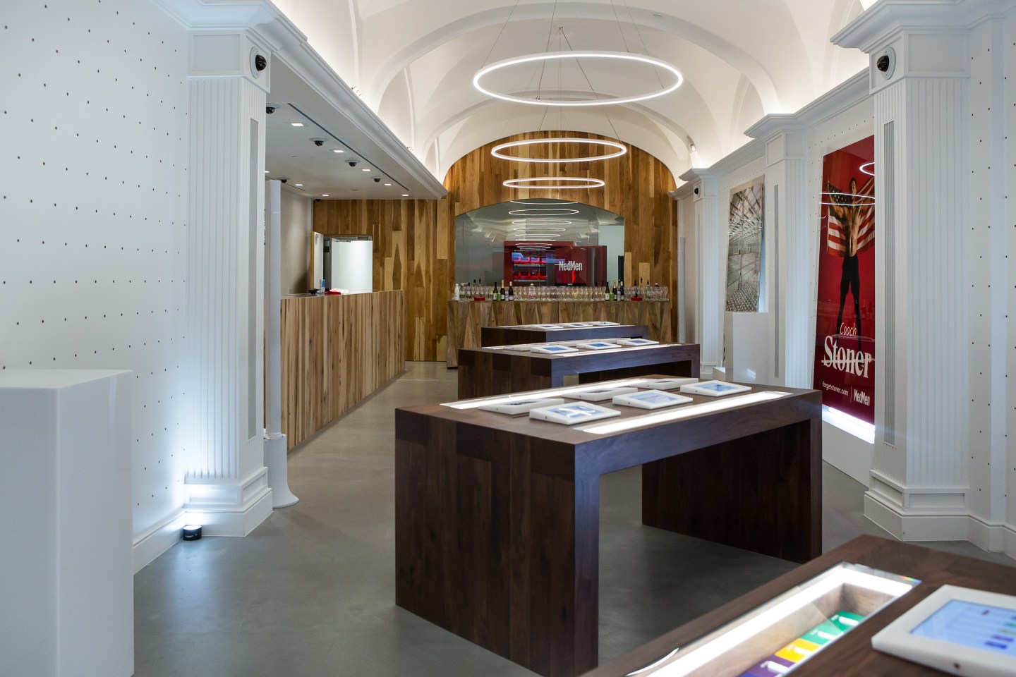 The inside of a medical marijuana dispensary, where tables with tablets allow customers to browse different strains of weed products.