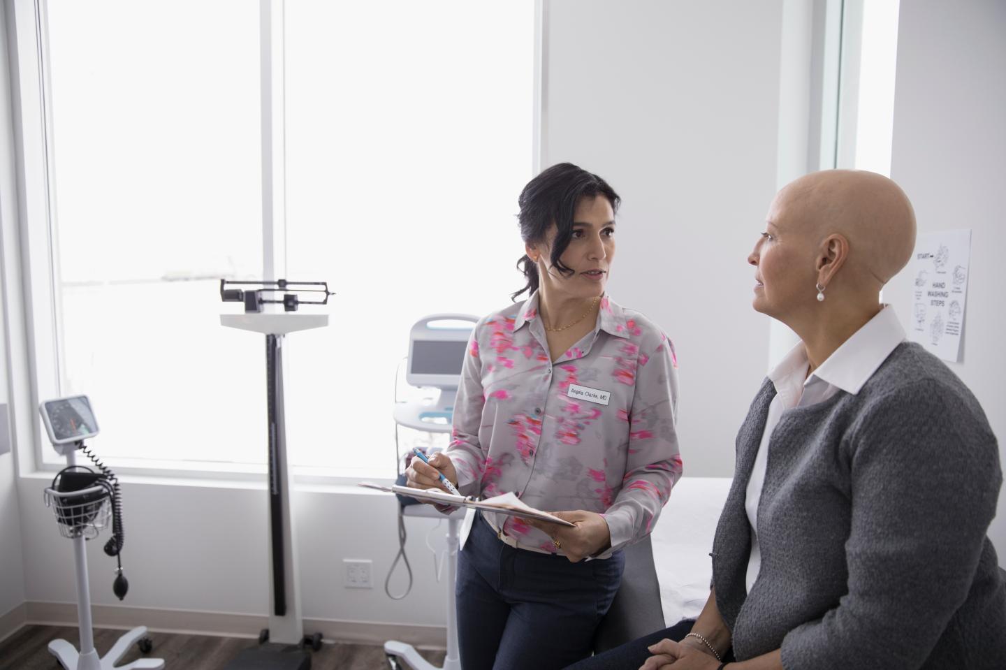 A doctor and patient talk in an examination room.