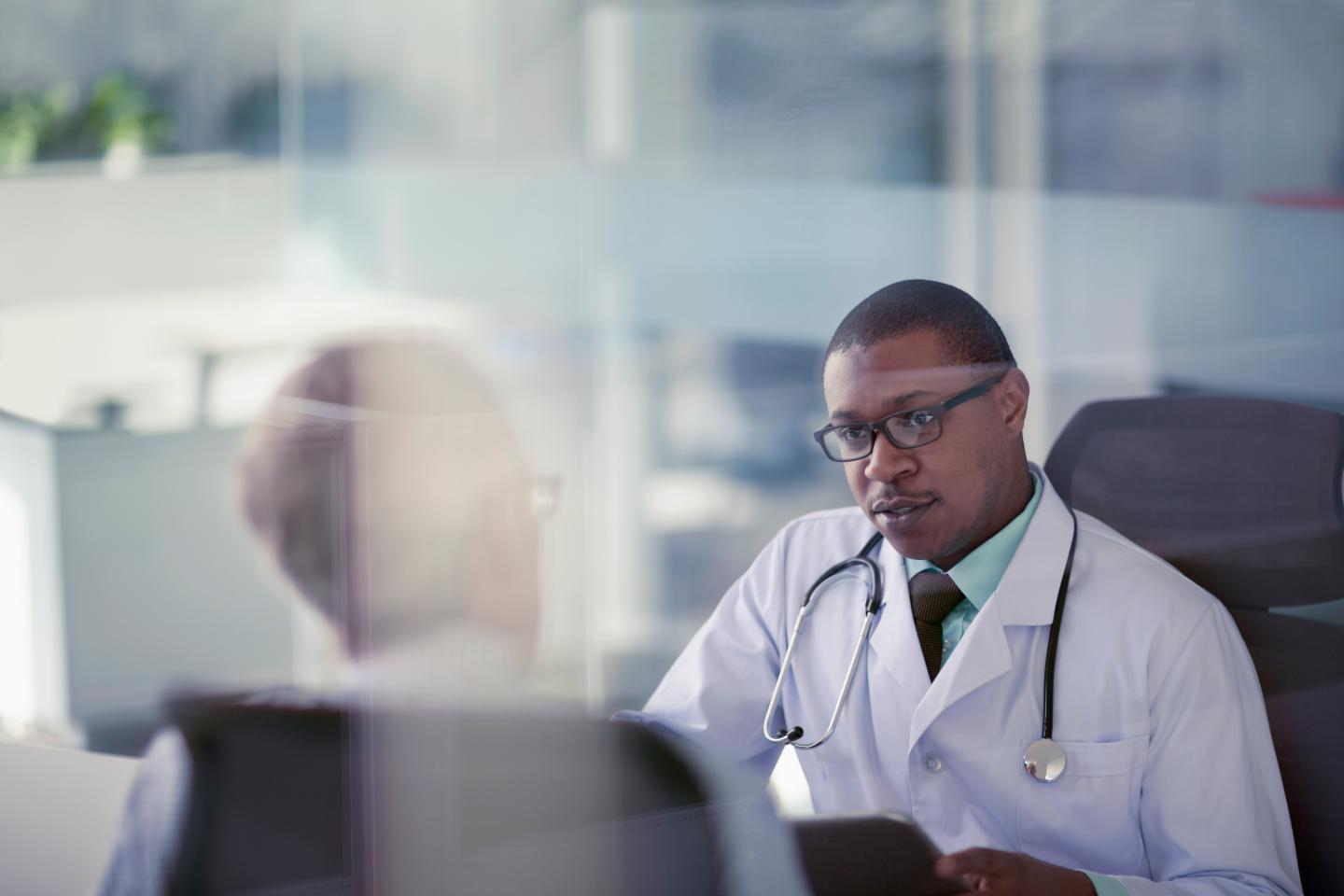 A physician speaking with a patient at the doctor's office.