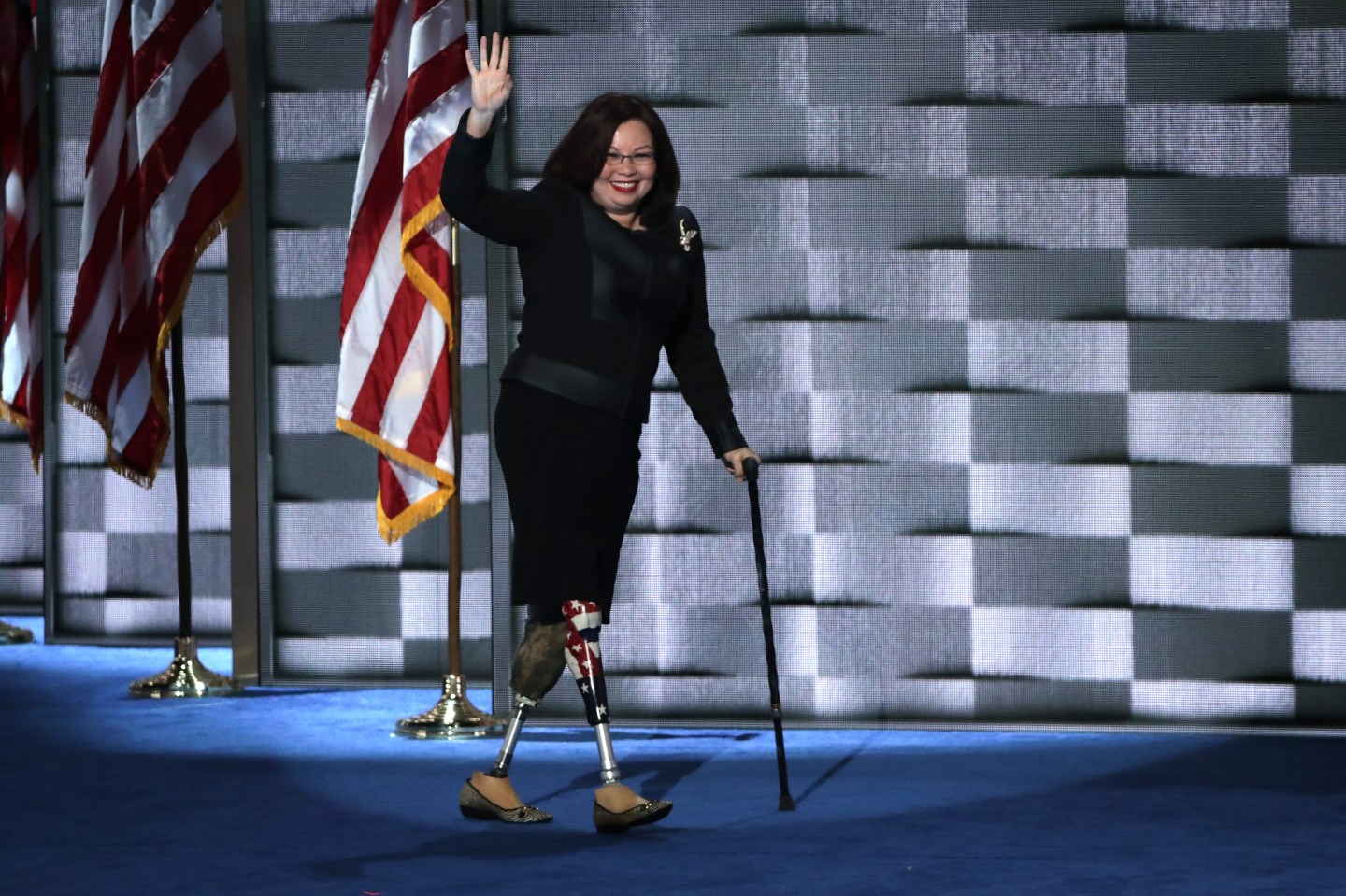 Tammy Duckworth walks across stage using prosthetic legs