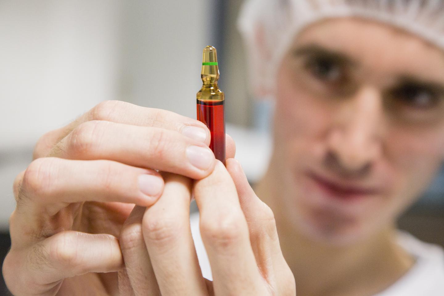 An employee inspects an ampoule of Neurobion vitamin supplement inside Merck KGaA's pharmaceutical laboratories
