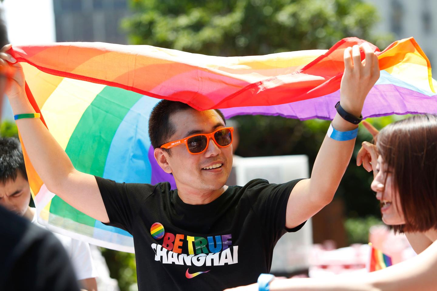 Man holds LGBT flag in Shanghai's Pride Run.