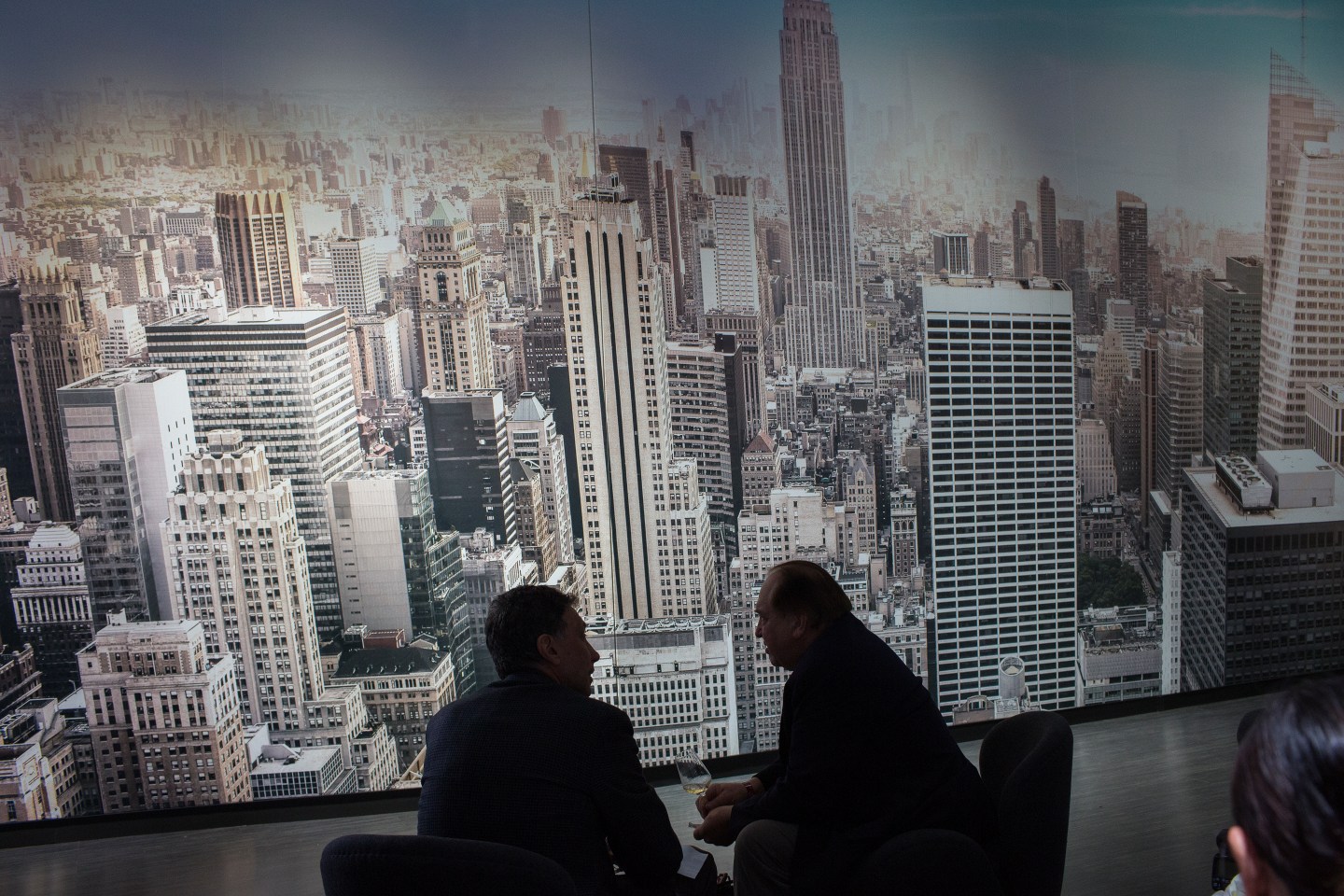 Two men silhouetted against New York City skyline.