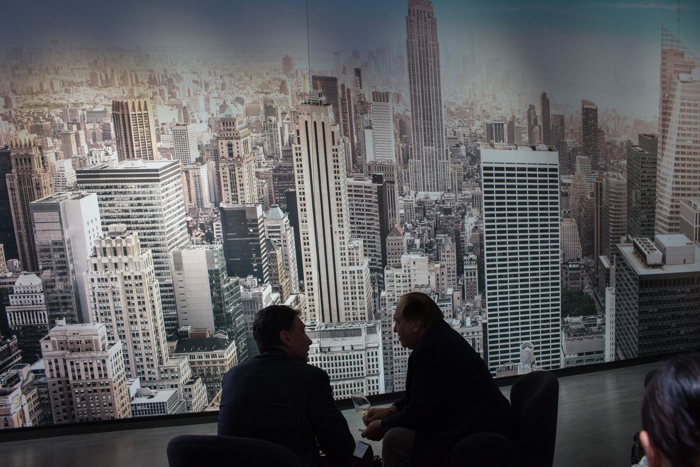 Two men silhouetted against New York City skyline.