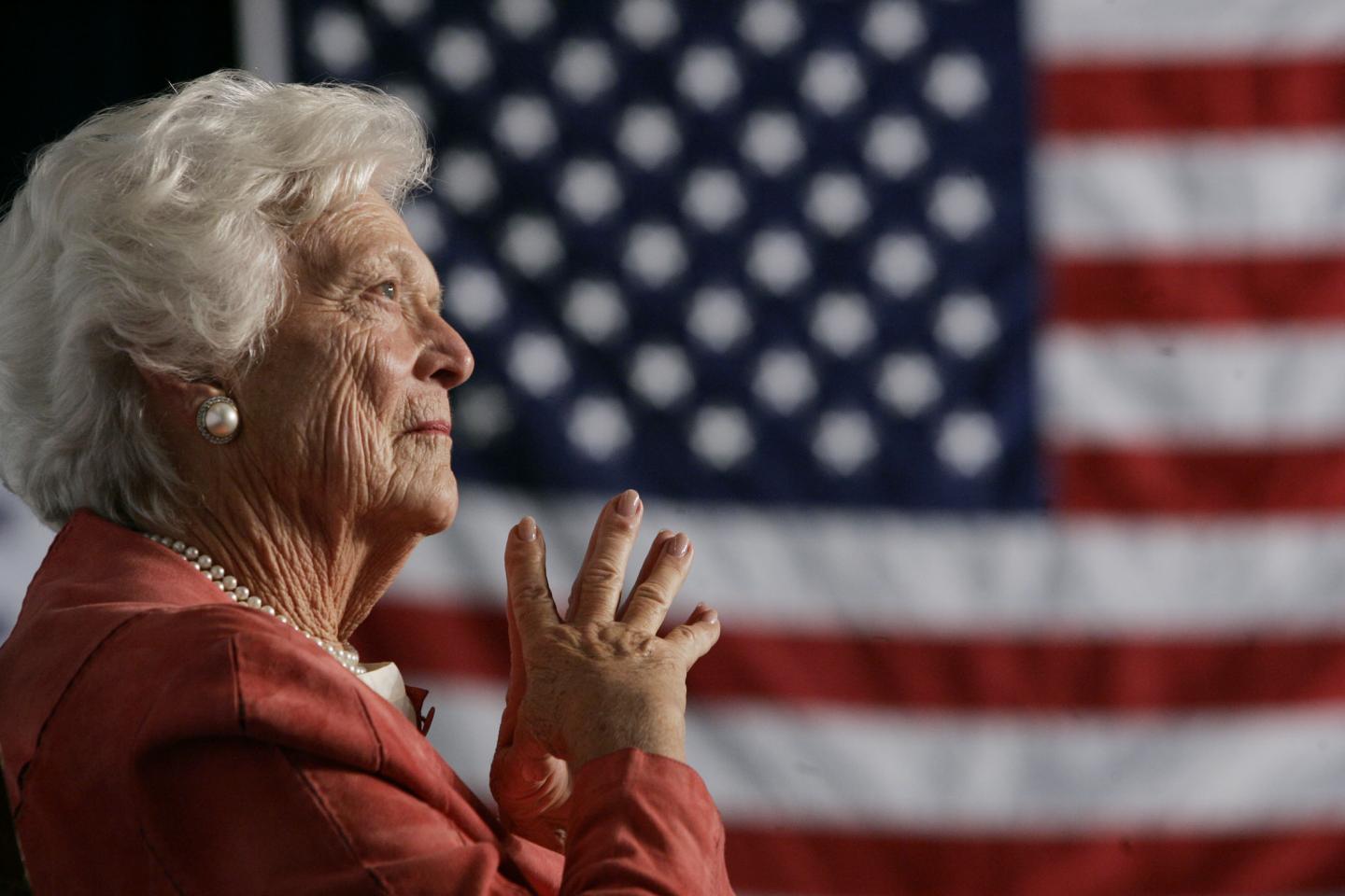 Former U.S. first lady Barbara Bush listens to her son President George W. Bush at an event in Orlando.