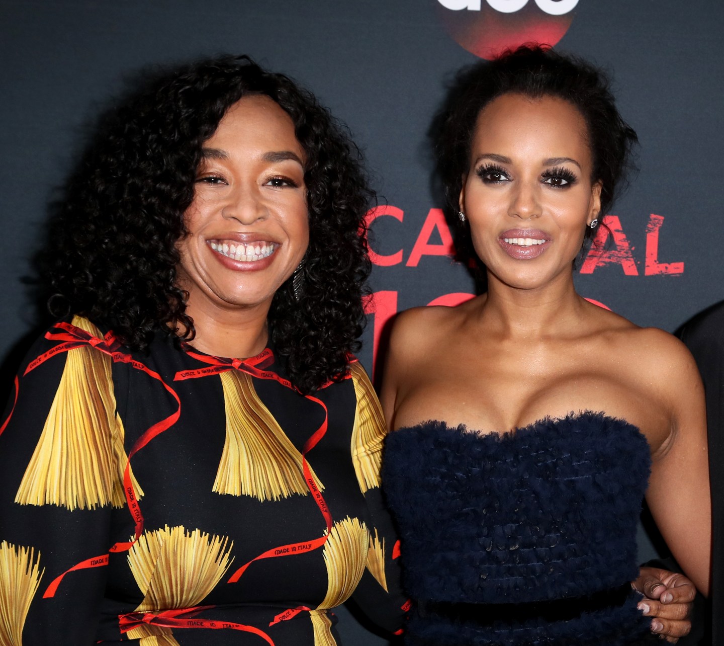 Shonda Rhimes and Kerry Washington pose together, smiling, on the red carpet for Scandal's 100th episode