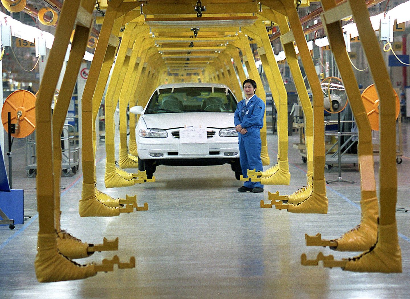 A worker stands by an assembly line making Buick s