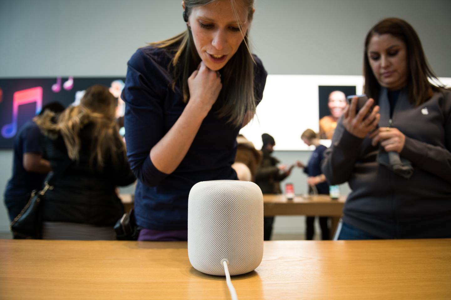 An employee speaks to Siri while demonstrating the Apple HomePod at an Apple store in New York.