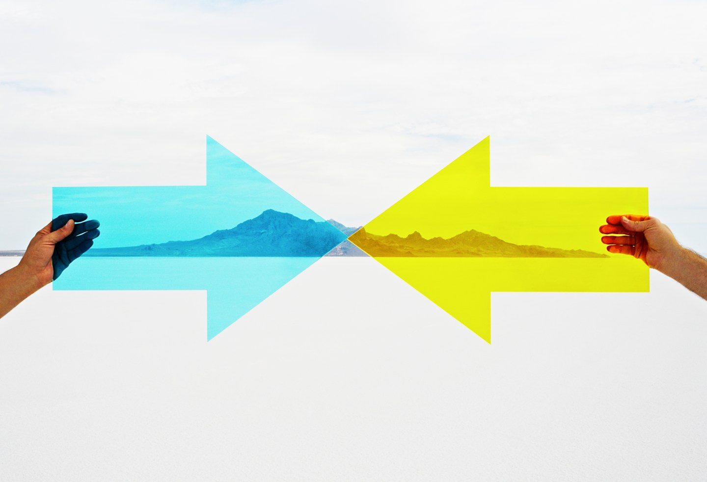 Two hands holding arrows pointed at each other.