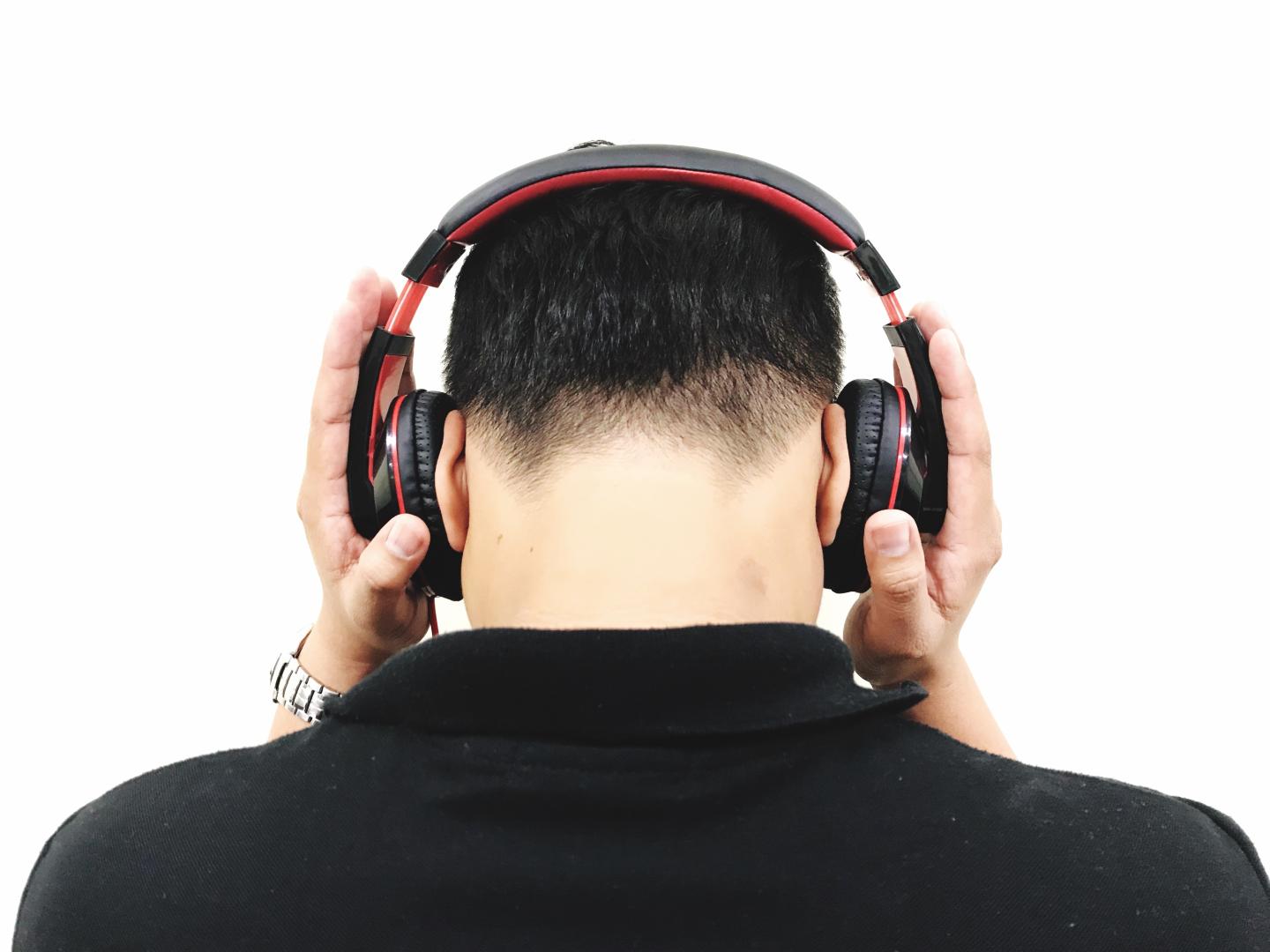 Rear View Of Man Listening Music Over White Background