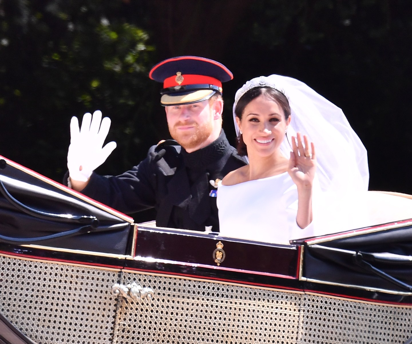 Prince Harry and Meghan Markle wave on carriage ride around Windsor after their wedding.
