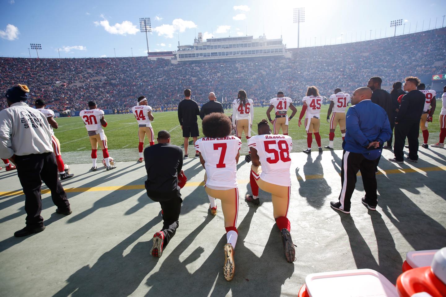 Eric Reid #35, Colin Kaepernick #7 and Eli Harold #58 of the San Francisco 49ers kneel next to each other on the sideline, during the anthem, prior to the game against the Los Angeles Rams at the Los Angeles Coliseum.