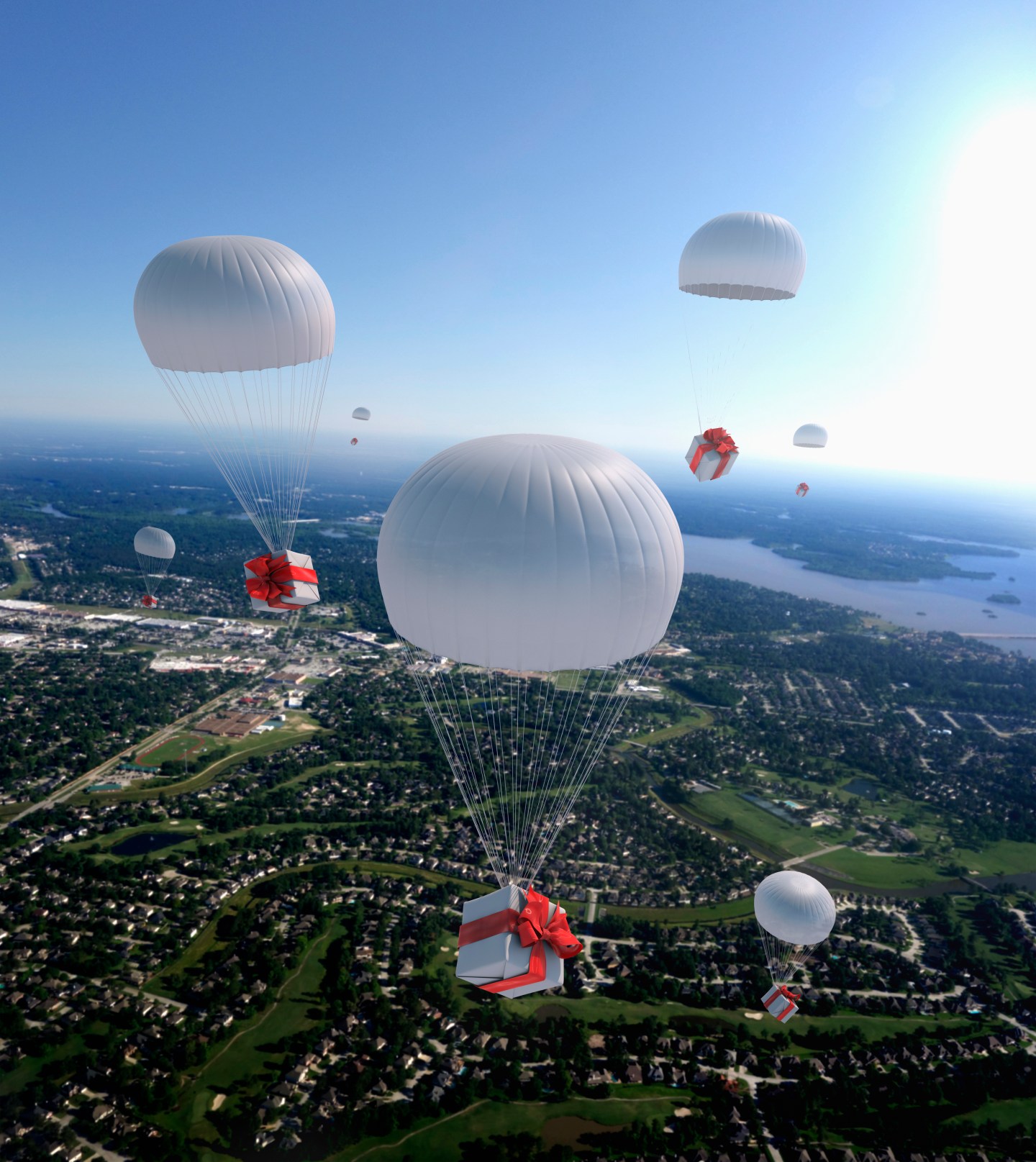 High angle view of gifts parachuting over suburban cityscape