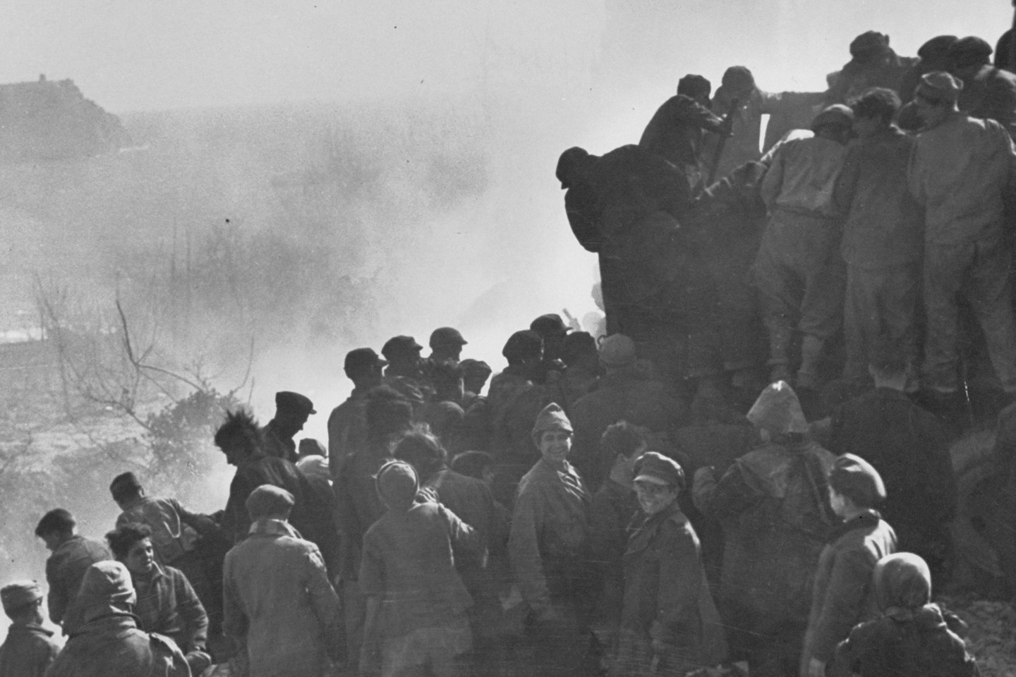Italian children living in postwar conditions pick over refuse dumped from garbage trucks.