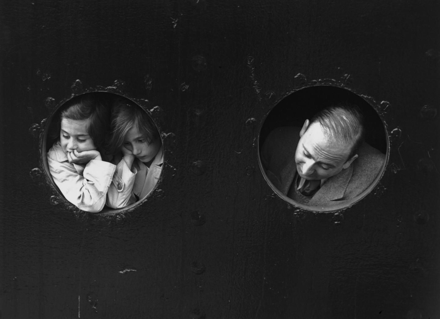 German Jewish refugees looking through portholes aboard the St. Louis ship on arrival at Antwerp, Belgium, in 1939.
