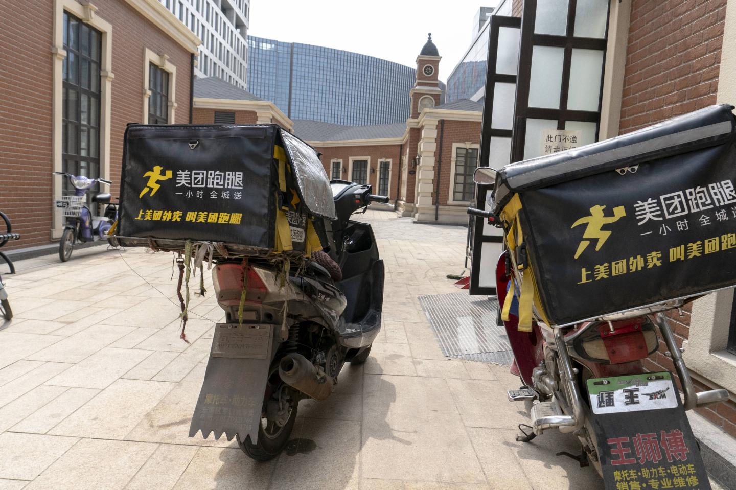 Motorcycles of Meituan.com stops outside a restaurant.