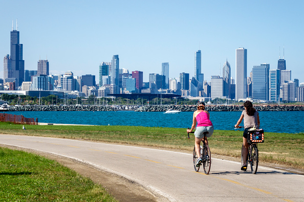 Illinois, Chicago, South Side, Lake Michigan, 39th Street Beach, Lakefront Trail, woman, friends, biker, bicycle, riding, city skyline, high rise skyscraper buildings,