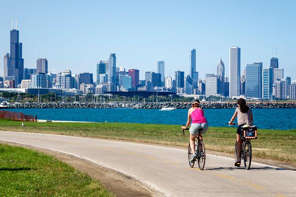 Illinois, Chicago, South Side, Lake Michigan, 39th Street Beach, Lakefront Trail, woman, friends, biker, bicycle, riding, city skyline, high rise skyscraper buildings,